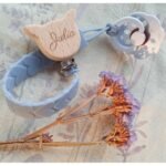 Durable silicone pacifier hanger featuring customizable name engraving and a secure clip, available in various colors. Perfect for keeping pacifiers within reach.