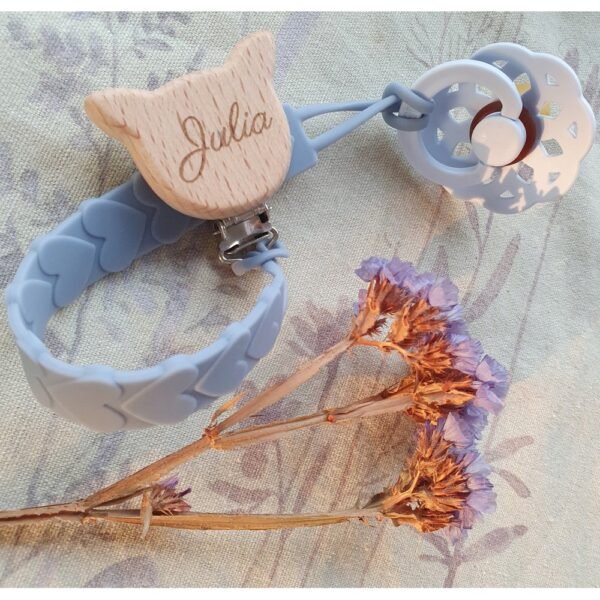 Durable silicone pacifier hanger featuring customizable name engraving and a secure clip, available in various colors. Perfect for keeping pacifiers within reach.
